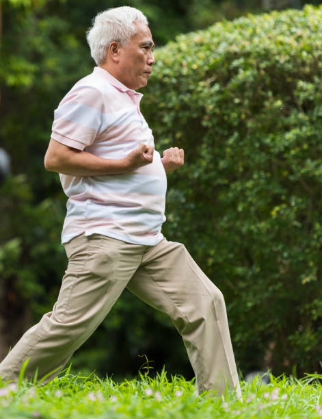 istock Side view senior man exercising in green park 1180450691