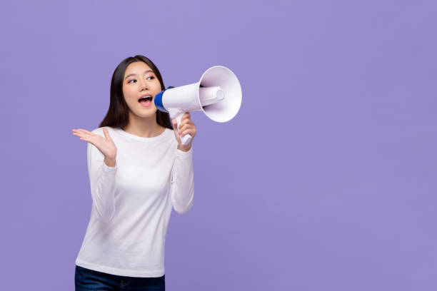 asiatische frau kündigt auf magaphone - megaphone women at attention using voice stock-fotos und bilder