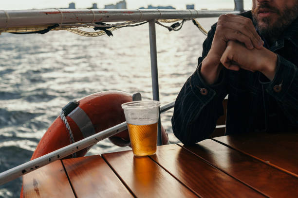 istock Plastic glass with beer stands on table above  river 1180451185