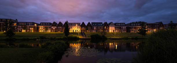 Panoramic view of modern houses in traditional dutch style along a canal in Holland Modern architecture in classical dutch style along the waterside in a town in The Netherlands. reflection lake stock pictures, royalty-free photos & images