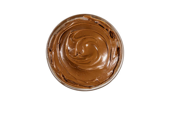 istock Glass bowl with delicious chocolate hazelnut spread isolated on white background. Top view 1180461183