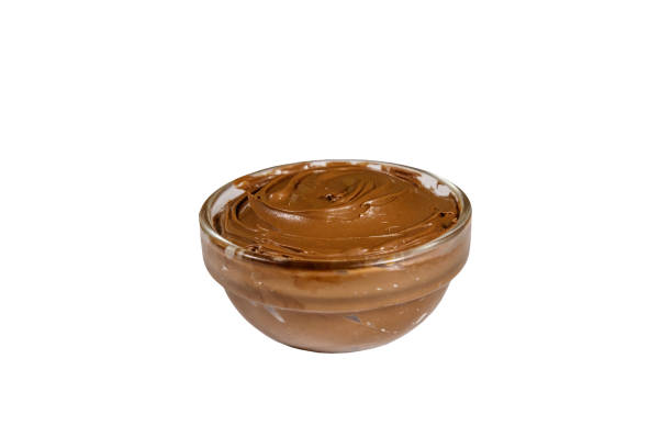 istock Glass bowl with delicious chocolate hazelnut spread isolated on white background 1180461191