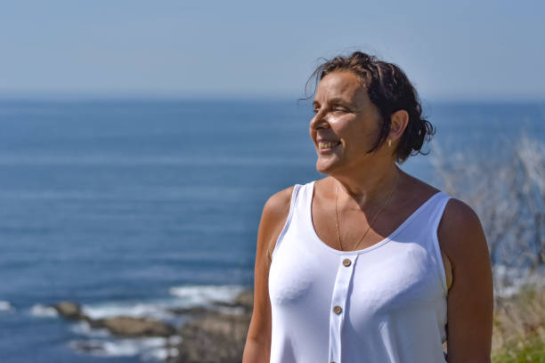 istock Mature woman by the sea side 1180461415