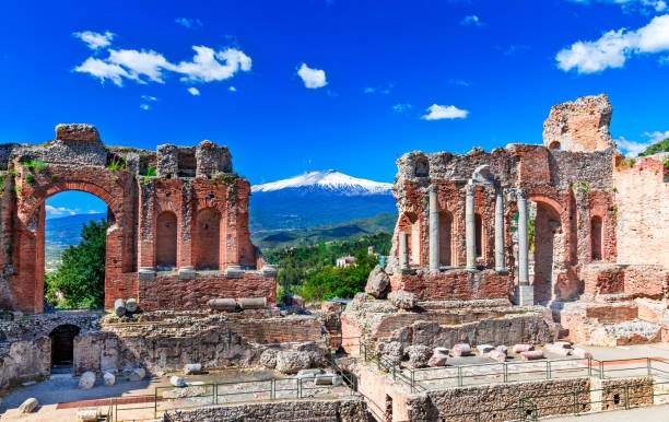 taormina, sicily, italy: the greek theater of taormina with smoking etna volcano in background - mt etna imagens e fotografias de stock