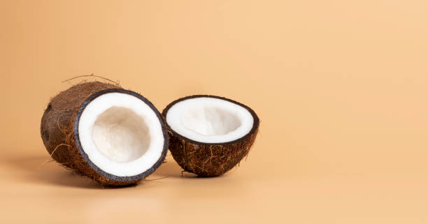 istock Sliced coconut on a soft orange background 1180465092