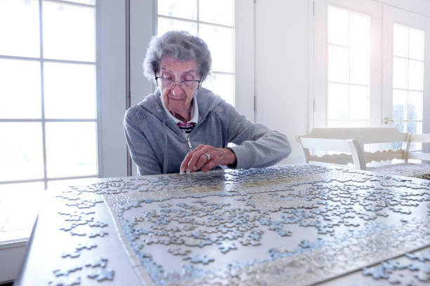 istock Elderly Woman Working On A Jigsaw Puzzle 1180465220