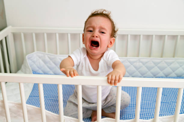 детские мальчик плачет в crib - crying grimacing facial expression human face стоковые фото и изображения