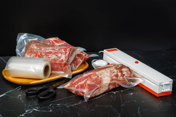 Vacuum sealer machine and meat . Vacuum sealer machine and meat on a dark background. airtight photos stock pictures, royalty-free photos & images