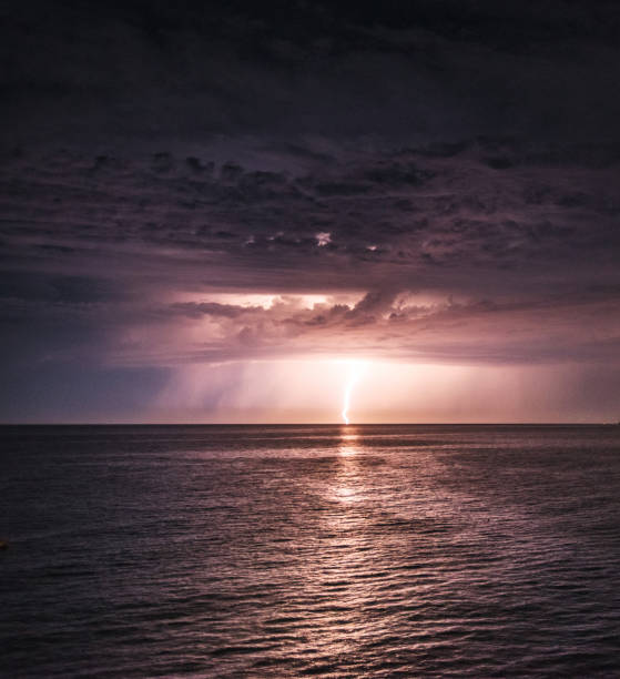 Lightning in the dark night sky over a sea