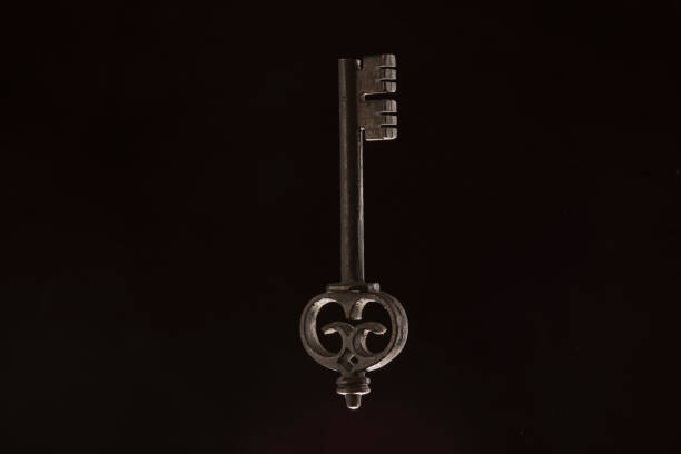 istock Vintage key on the black background 1180475315