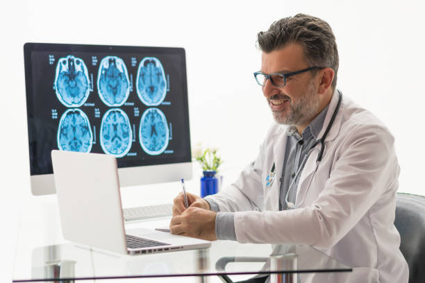 istock Doctor working on desk with laptop 1180483484