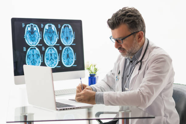 istock Doctor working on desk with laptop 1180483546