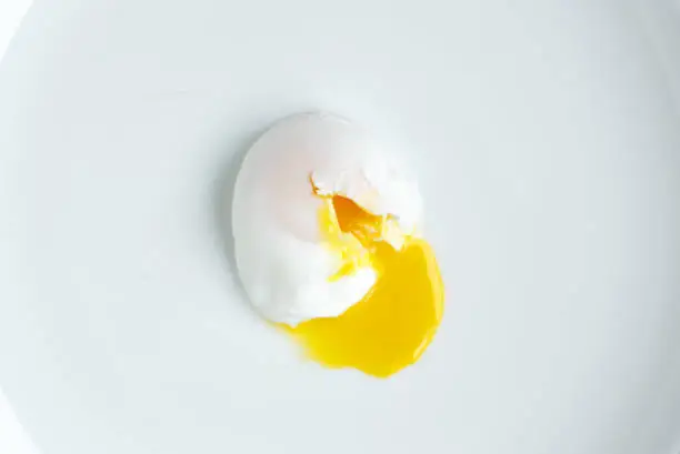 Photo of poached egg closeup shot on white background