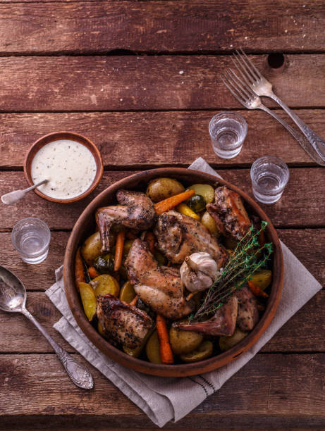 istock Rabbit baked with potatoe and herbs in a pot, copy space 1180485336