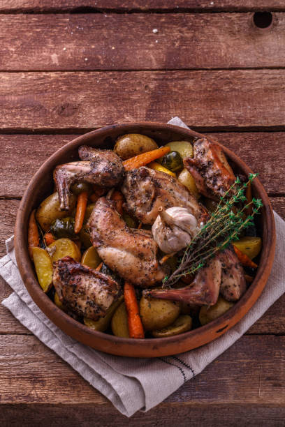istock Rabit with root vegetables and herbs on wooden background, copy space 1180485343