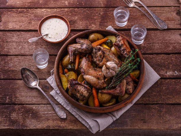 istock Oven baked rabbit with root vegetables and herbs, rustic style 1180485348