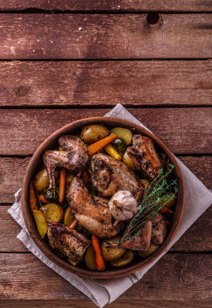 istock Rabit with potatoes and herbs on wooden background, copy space 1180485353