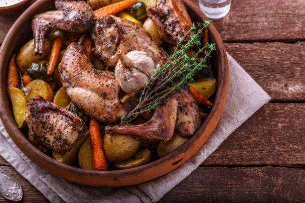 istock Oven baked rabbit with root vegetables and herbs, rustic style 1180485357