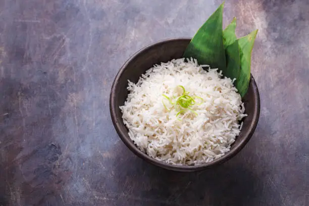 Photo of Nasi lemak or Malay fragrant rice cooked in coconut milk and pandan leaf, copy space