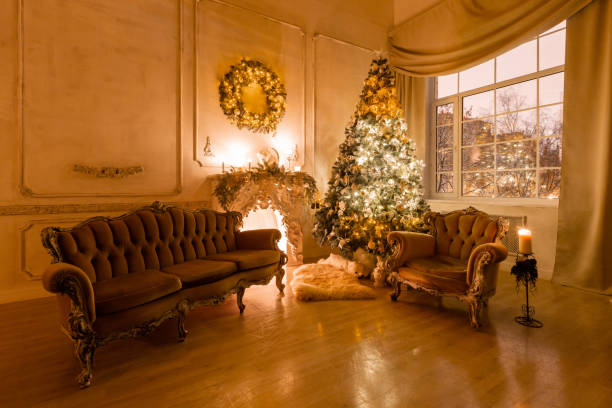 istock Christmas evening by candlelight. classic apartments with a white fireplace, decorated tree, sofa, large windows and chandelier. 1180485396