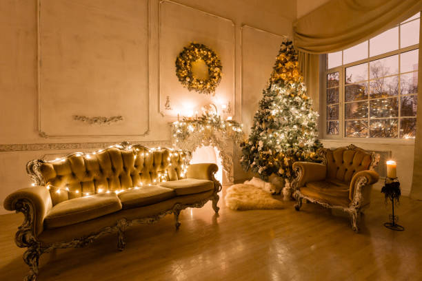 istock Christmas evening by candlelight. classic apartments with a white fireplace, decorated tree, sofa, large windows and chandelier. 1180485930