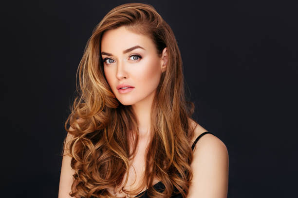 istock Blonde woman posing against black background 1180487463