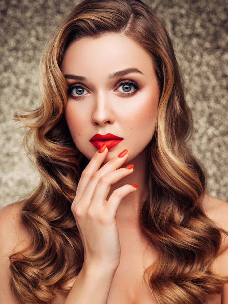 istock Girl applying red lipstick on her lips 1180489260