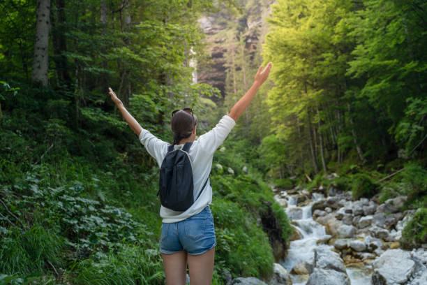 istock Young Woman Embracing Nature With Arms Outstretched 1180492768