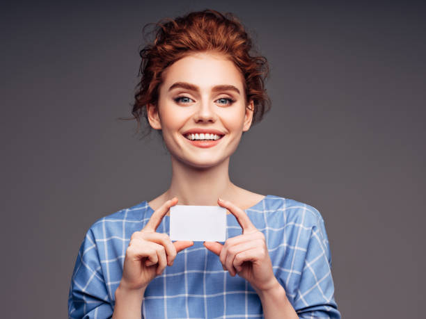 istock Young woman holding a business card 1180493907