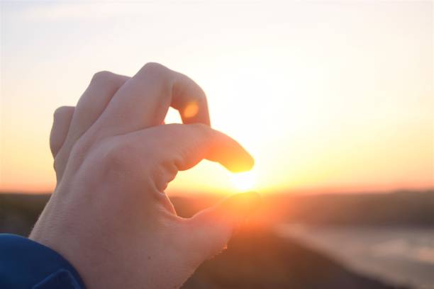 istock Hand pinching rising sun 3 1180496009