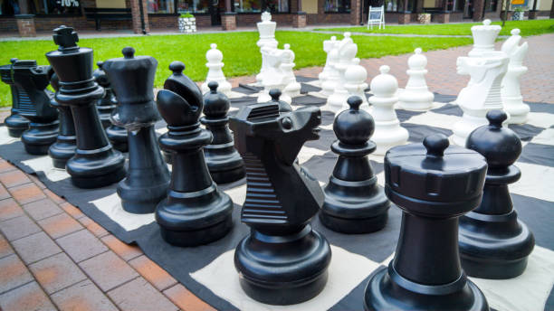 istock Closeup image of black and white big chess figures for playing in park. 1180497467
