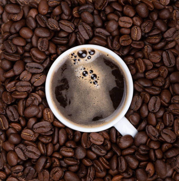 istock Coffee cup with black freshly brewed coffee among coffee beans. 1180498817