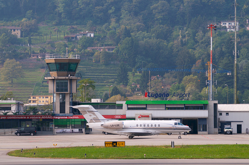 Agno, Ticino, Switzerland - 6th October 2019 : View on the Lugano-Agno airport with a parked small airplane located in the Canton of Ticino, Switzerland