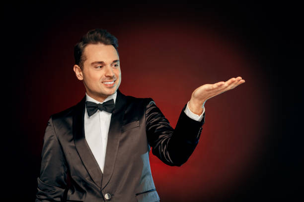 istock Professional Occupation. Showman in suit standing isolated on wall showing copy space smiling happy 1180508585