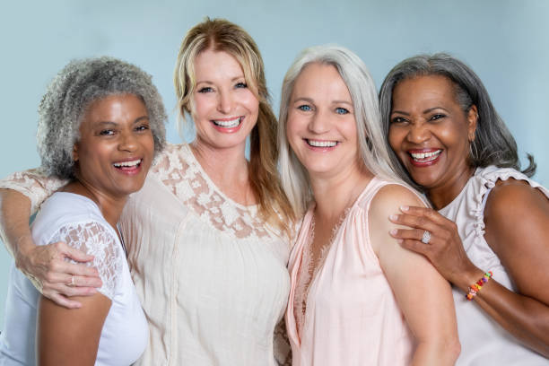 diversas mujeres mayores sonríen para retrato de estudio - skin care blue eyes expressing positivity cheerful fotografías e imágenes de stock