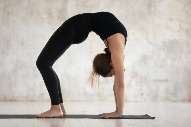 istock Young woman practicing yoga, Bridge exercise, Urdhva Dhanurasana 1180509394