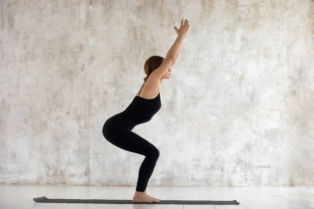 istock Beautiful woman practicing yoga, Chair exercise, Utkatasana pose 1180509433