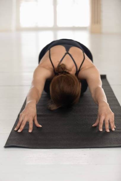 istock Woman practicing yoga, Child pose, Balasana exercise, vertical photo 1180509438