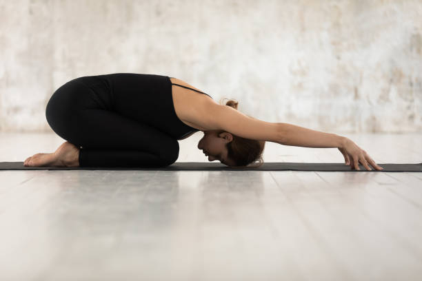 istock Beautiful woman practicing yoga, relaxing in Child pose, Balasana exercise 1180509455