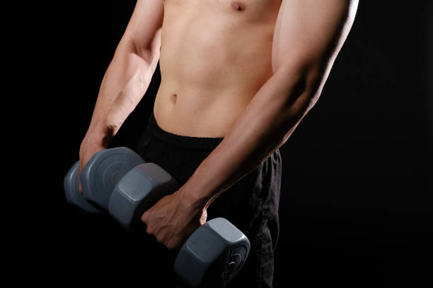 istock athletic muscular bodybuilder man with naked torso six pack abs working out with dumbbell. fitness  exercise concept 1180509463