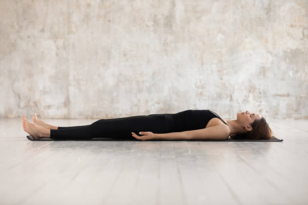 istock Young woman practicing yoga, Savasana, Dead Body pose, Corpse 1180509477