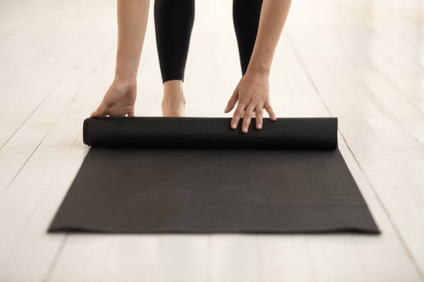 istock Woman rolling mat before or after practicing yoga close up 1180509546