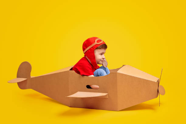 istock Joyful boy playing with cardboard airplane 1180509712