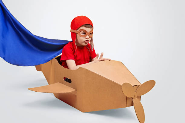 istock Captivated boy playing with cardboard airplane 1180509715