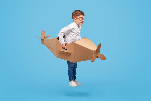 istock Cheerful aviator playing with cardboard aircraft 1180509728