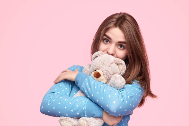 istock Cute teenager hugging teddy bear 1180509781