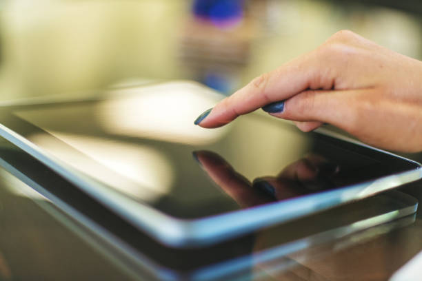 istock Female hands using digital tablet in bright friendly backlit by natural window light office setting completing paperwork and working with technology and enjoying working together as professional advisor and client in Western Colorado 1180518609