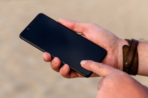 istock Close up of a man using mobile smart phone outdoor 1180520221