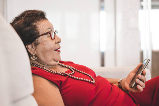 Grandmother using smart phone on the sofa