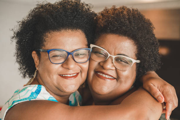 gelukkige zusters - eeneiige tweeling stockfoto's en -beelden